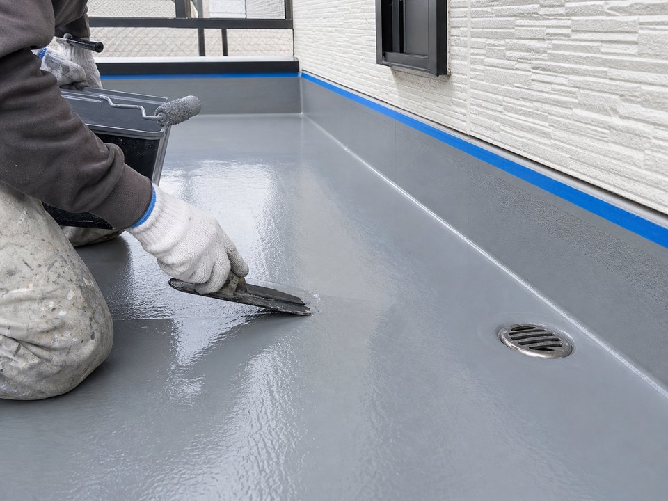 ベランダ床に防水材を施工する手元